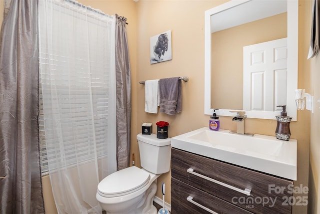 bathroom with a shower with curtain, vanity, and toilet