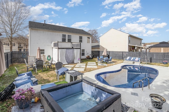 back of property with a patio area, a swimming pool with hot tub, and a balcony