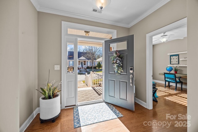 entryway with ceiling fan, crown molding, and hardwood / wood-style flooring