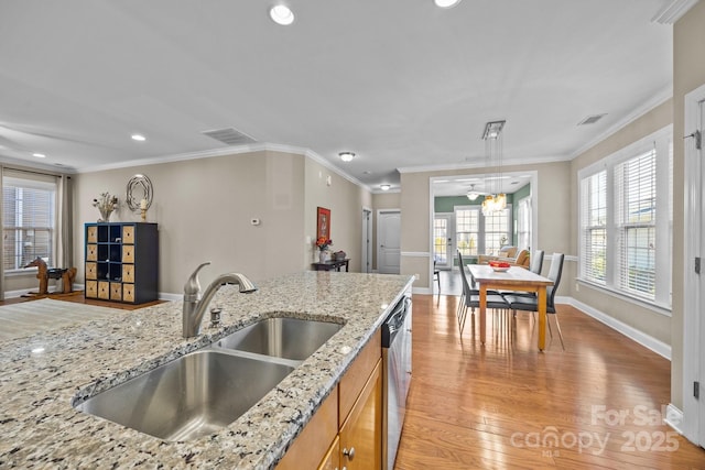 kitchen featuring light stone counters, dishwasher, light wood-type flooring, crown molding, and sink