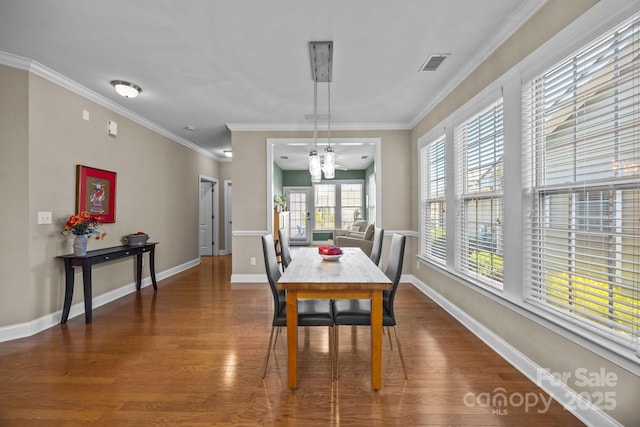 dining area featuring ornamental molding, an inviting chandelier, and wood-type flooring