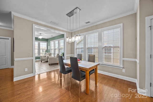 dining room featuring ceiling fan, light wood-type flooring, and crown molding