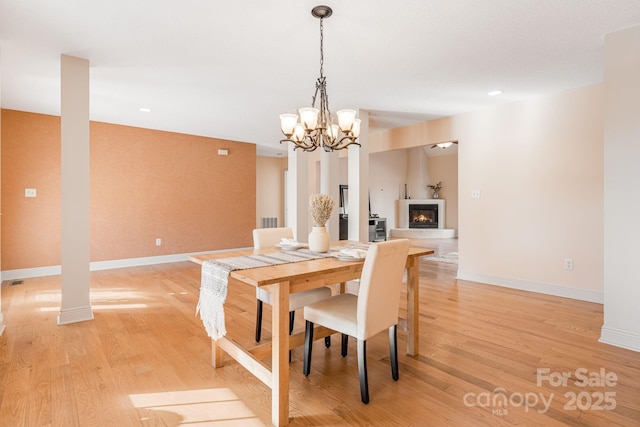 dining space featuring light hardwood / wood-style flooring and a chandelier