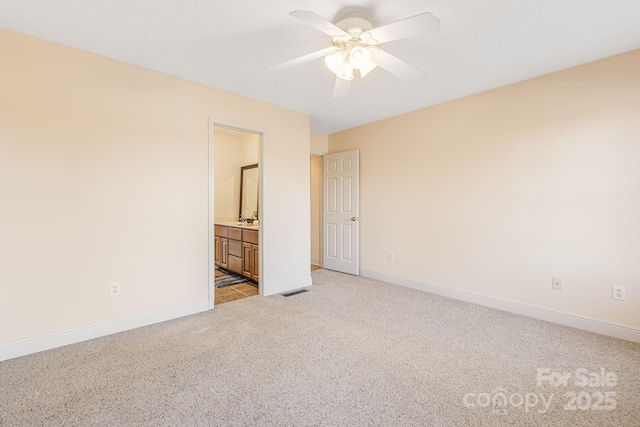 unfurnished bedroom featuring sink, ensuite bath, ceiling fan, and light colored carpet