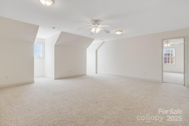 bonus room featuring ceiling fan, lofted ceiling, and plenty of natural light