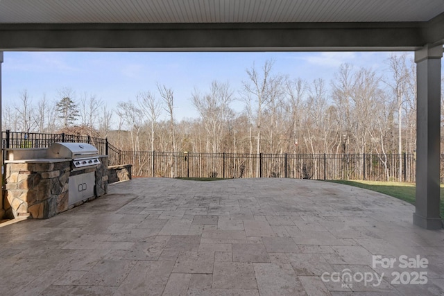 view of patio with area for grilling, an outdoor kitchen, and a fenced backyard