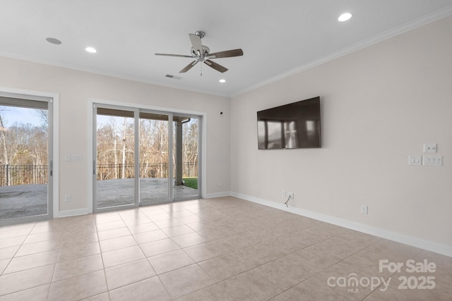 empty room featuring a wealth of natural light, baseboards, visible vents, and crown molding