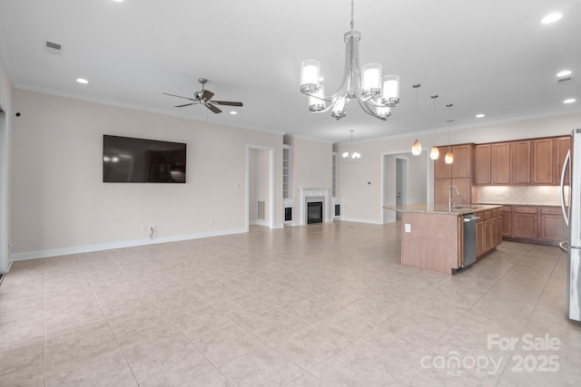 kitchen featuring an island with sink, brown cabinets, open floor plan, hanging light fixtures, and stainless steel appliances