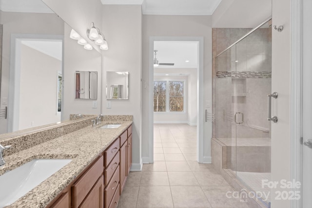 bathroom featuring ornamental molding, a stall shower, a sink, and tile patterned floors