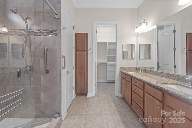 bathroom with crown molding, a stall shower, and a sink