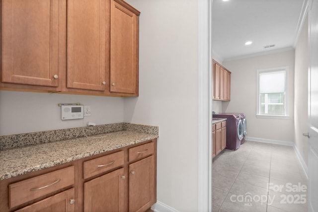 kitchen featuring visible vents, baseboards, light stone countertops, brown cabinetry, and crown molding