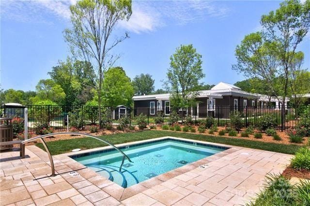 view of swimming pool featuring fence and a patio