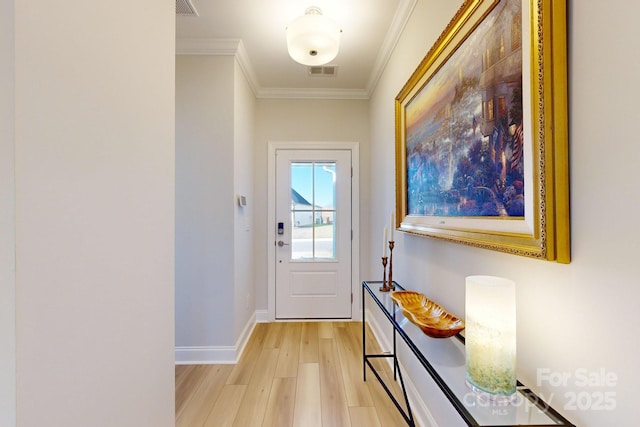 entryway featuring ornamental molding and light hardwood / wood-style flooring