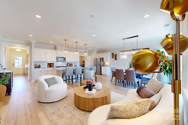 living room with light hardwood / wood-style floors and crown molding