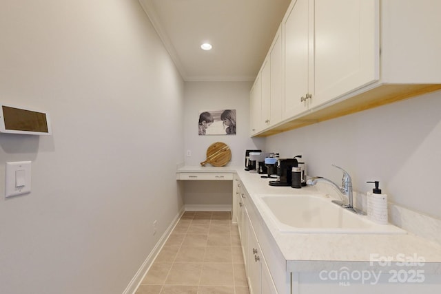 interior space featuring white cabinets, ornamental molding, sink, and light tile patterned floors