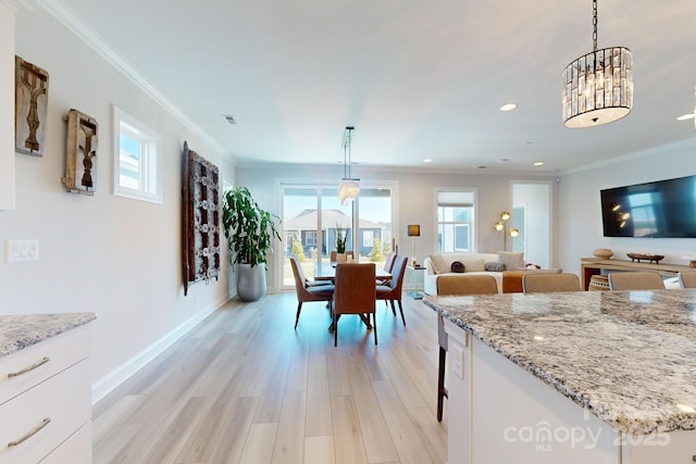 dining space featuring light hardwood / wood-style floors and crown molding