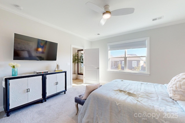 carpeted bedroom featuring ceiling fan, ensuite bathroom, and crown molding