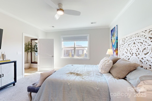 carpeted bedroom featuring ceiling fan, ensuite bathroom, and ornamental molding