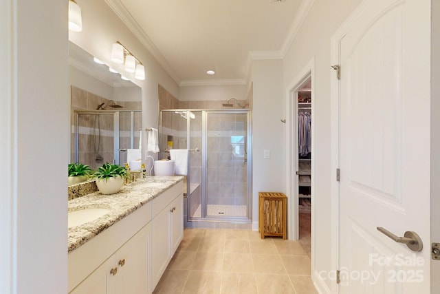 bathroom featuring tile patterned flooring, vanity, a shower with door, and crown molding