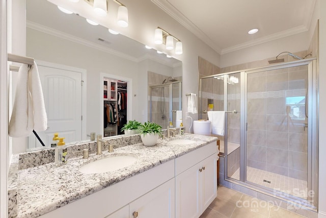 bathroom with tile patterned flooring, vanity, a shower with door, and ornamental molding