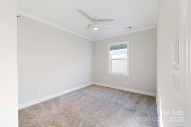 carpeted spare room featuring ceiling fan and ornamental molding