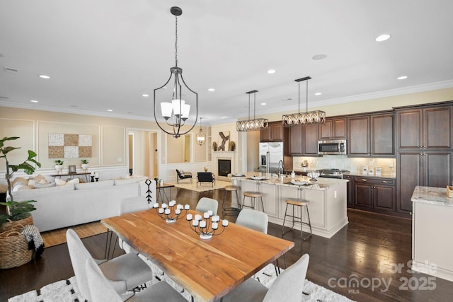 dining area featuring dark hardwood / wood-style flooring, sink, and ornamental molding