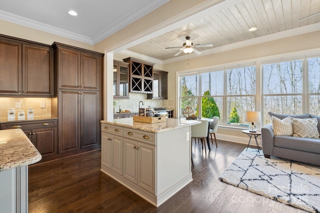 kitchen with tasteful backsplash, ornamental molding, a kitchen island, and wooden ceiling