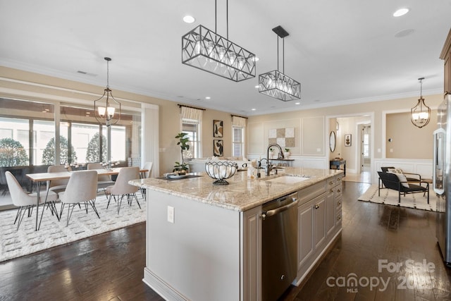 kitchen featuring decorative light fixtures, dishwasher, sink, and a center island with sink