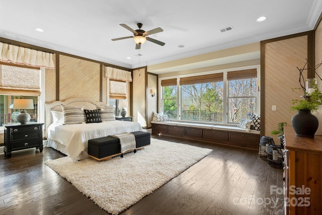 bedroom featuring crown molding, dark wood-type flooring, wooden walls, and ceiling fan