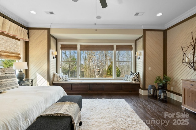 bedroom featuring crown molding, ceiling fan, dark hardwood / wood-style floors, and wood walls