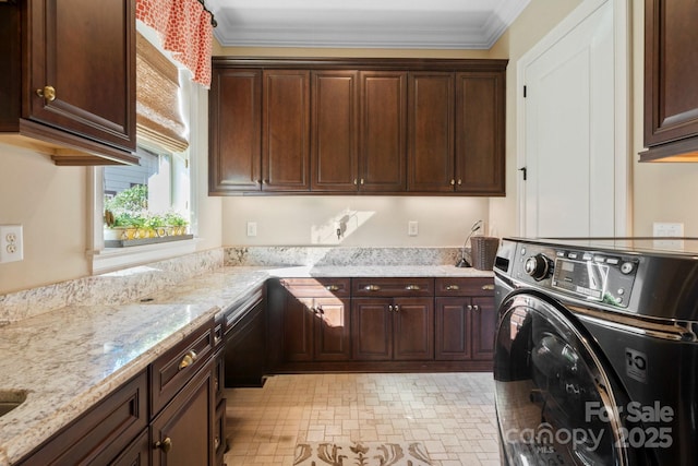 washroom with crown molding, washing machine and dryer, and cabinets