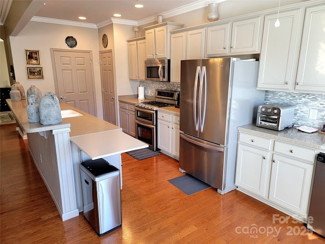 kitchen featuring tasteful backsplash, crown molding, stainless steel appliances, and a center island