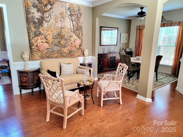 living room featuring ceiling fan, wood-type flooring, and ornamental molding