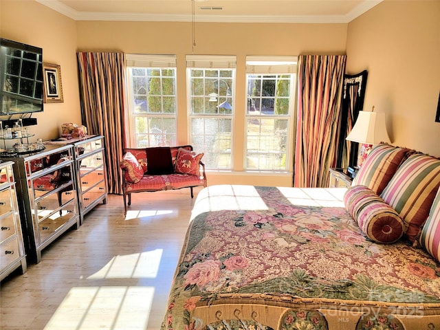 bedroom with light hardwood / wood-style flooring and crown molding