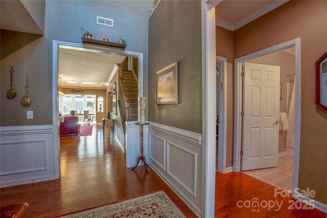 hallway featuring ornamental molding and light hardwood / wood-style flooring