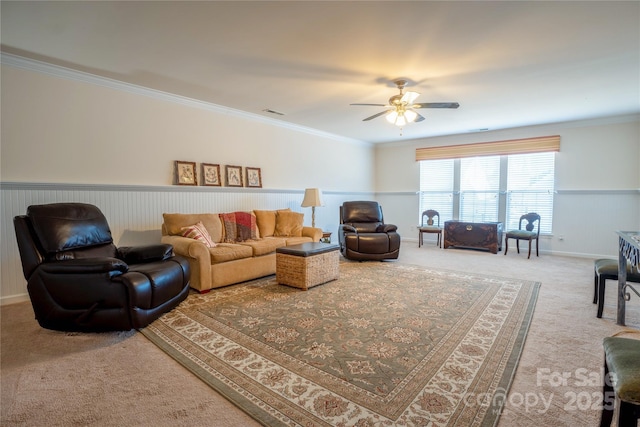 carpeted living room with ceiling fan and crown molding