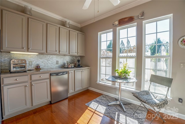 kitchen with backsplash, light wood-type flooring, ceiling fan, stainless steel dishwasher, and crown molding