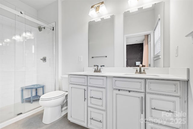 bathroom with tile patterned floors, vanity, toilet, and a shower with shower door