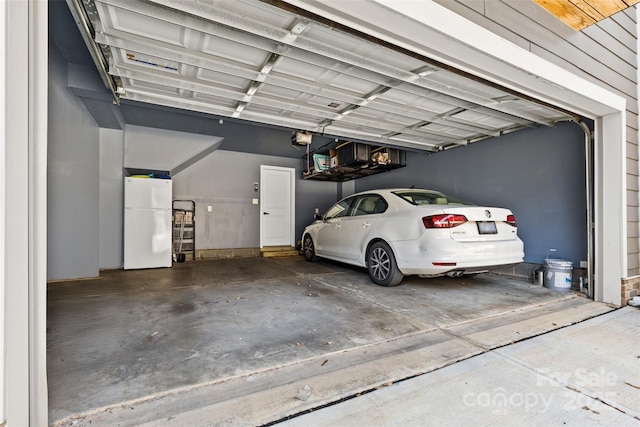 garage with white fridge and a garage door opener