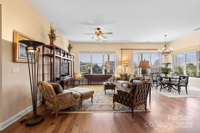 living room featuring hardwood / wood-style flooring, plenty of natural light, and ceiling fan with notable chandelier