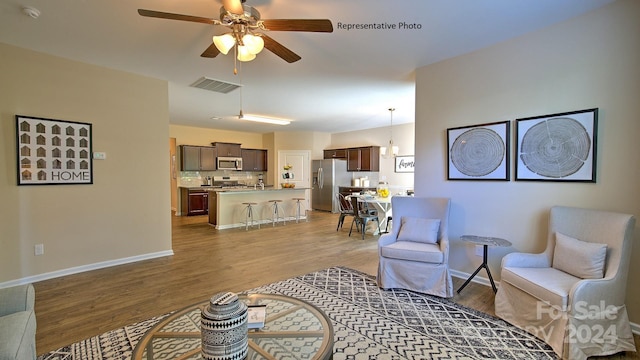 living room featuring light hardwood / wood-style floors and ceiling fan