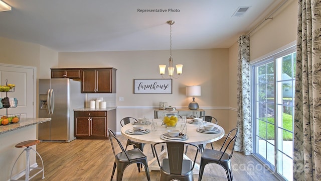 dining area featuring light hardwood / wood-style flooring and a chandelier