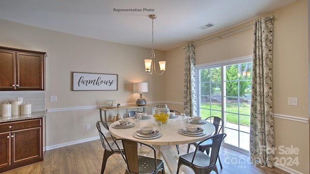 dining room featuring hardwood / wood-style flooring and a notable chandelier