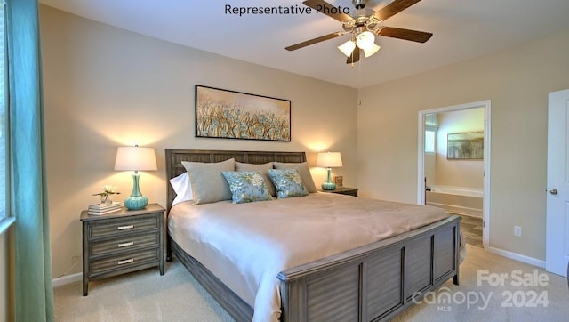 bedroom with ceiling fan, light colored carpet, and connected bathroom