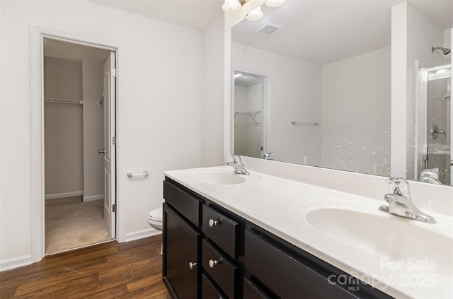 bathroom with visible vents, an enclosed shower, wood finished floors, and a sink