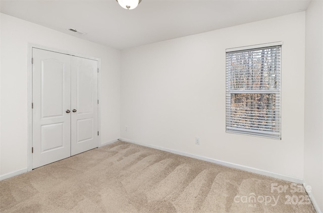 unfurnished bedroom featuring baseboards, a closet, and carpet floors