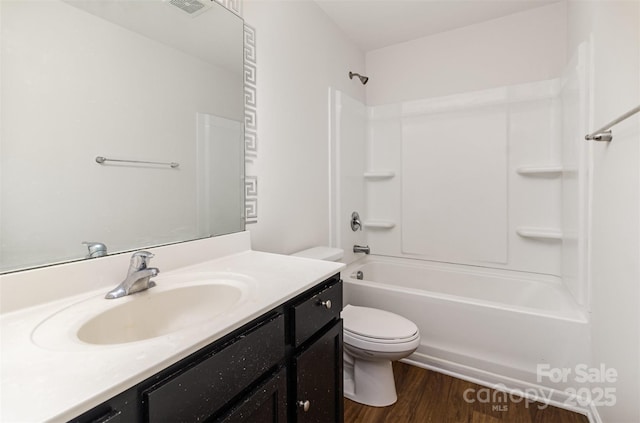 full bath featuring bathtub / shower combination, wood finished floors, toilet, and vanity