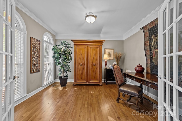 office featuring ornamental molding, light hardwood / wood-style flooring, and french doors