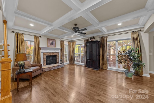 living room featuring beam ceiling, ceiling fan, a fireplace, and coffered ceiling