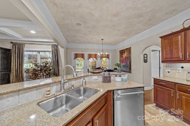 kitchen featuring stainless steel dishwasher, light stone counters, sink, and a chandelier